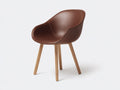 Silla de comedor tapizada en piel sintética con patas de madera 60 x 58 x 82 cm - marrón coñac y roble natural - diseño moderno envolvente